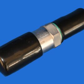 HH41 – LIMITEUR DE PRESSION DB12120A-011-CE1637ENISO41266L11025 Close-up of a black cylindrical tube with a silver hex nut and green gasket against a blue background.