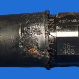 Close-up of a black cylindrical device with metal bands and stamped numbers on a blue background.
