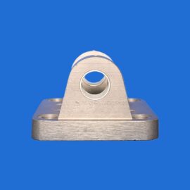 Close-up of a silver metal bracket with a circular hole, mounted on a base against a blue background.