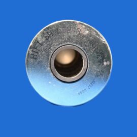 Close-up of a metallic spool/bearing edge with a central hole on a blue background, showing wear from use.