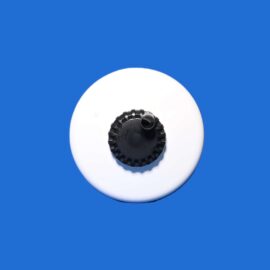 White circular plate with a black, ridged center piece on a blue background