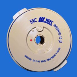 Close-up of a beige circular device with a small red indicator dot and blue text around its rim on a solid blue background.