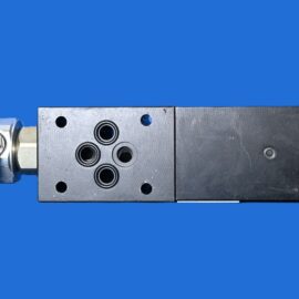 Metal hydraulic valve block with four circular ports and fittings mounted on a blue background.