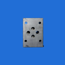 Close-up of a perforated metal plate with round holes against a solid blue background, visible from the lower center of the image.
