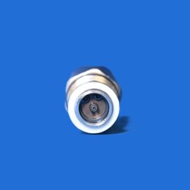 Macro shot of a circular metallic connector with four small pins, embedded in a white housing against a solid blue background.