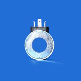 Close-up of a metallic circular component with three flat prongs on a black top, set against a solid blue background.