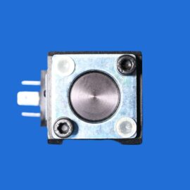 Close-up of a small metal device with circular dials and a textured surface against a blue background, likely a camera or precision instrument panel.