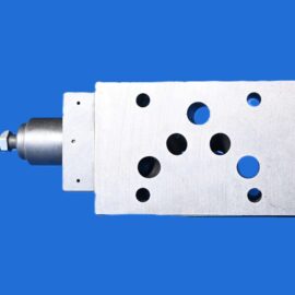 Metal perforated drilling jig with several holes and a drill chuck on the left, set against a solid blue background.