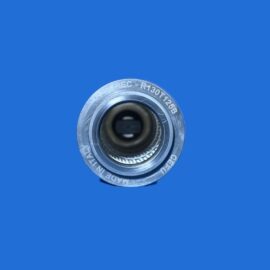 Close-up of a metal camera lens barrel facing the viewer against a solid blue background.