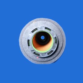 Close-up of a circular grinding wheel with orange abrasive core and green accents against a blue background