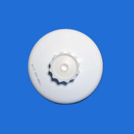 Close-up of a white circular object with a knob on a bright blue background.