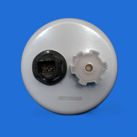 Close-up of a white circular device base showing a black electrical connector on the left and a gray gear-like insert on the right, against a solid blue background.