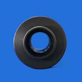 Close-up of a black rubber washer with a central hole on a bright blue background online.