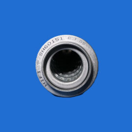 Close-up of a metallic camera lens barrel against a solid blue background with the lens opening visible at the bottom edge.