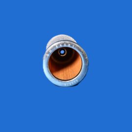 Close-up of a metal camera lens opening facing the viewer against a solid blue background with an orange interior edge visible around the rim.