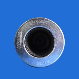 Close-up of a weathered silver metal ring with engraved code SH65001 and other markings against a solid blue background, inner black cavity visible.