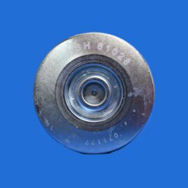 Close-up of a worn metal circular dial against a solid blue background.