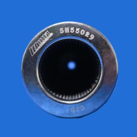 Close-up of a metal circular socket with knurled inner edge against a blue background, photographed from the side.
