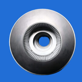 Close-up of a shiny metal circular component with concentric ridges against a solid blue background
