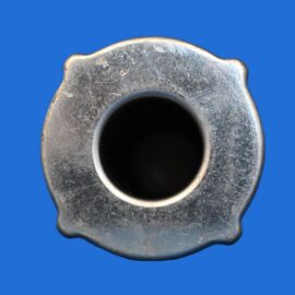 Top-down view of a worn metal flange with a circular central bore on a bright blue background.”,