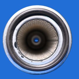 Close-up of a loudspeaker cone with a metal rim and mesh interior, set against a blue background