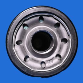 Close-up of a steel car wheel rim with bolt holes against a blue background