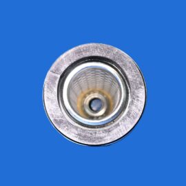 Macro shot of a silver metal circular component with an inner bore on a solid blue background (close-up)