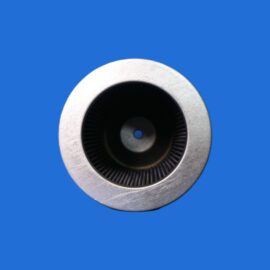 Close-up of a silver turbine housing with dark interior blades against a solid blue background, centered in the frame.