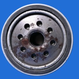 Close-up of a rusty metal wheel rim with bolt holes, set against a solid blue background.