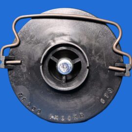 Close-up of a round black mechanical component with a curved metal tension band on a blue background. (informative)