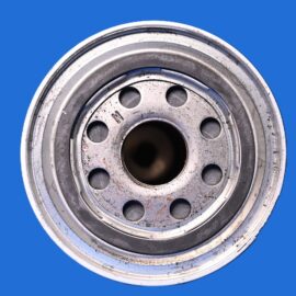 Close-up of a metal car wheel rim with dirt and rust, set against a solid blue background