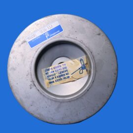 Close-up of a weathered metal circular component with a blue label and a taped note inside, against a blue background.