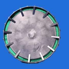 Close-up of a round metal mechanical part with a green gasket, set against a blue background.